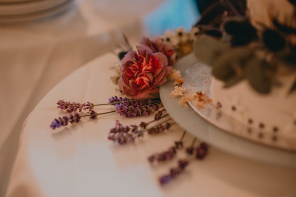 Bunte Blumenarrangements auf einem Tisch mit feinem Geschirr.