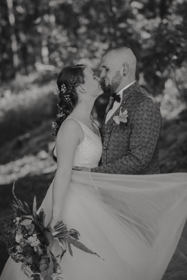Braut und Bräutigam teilen einen romantischen Moment in der Natur.